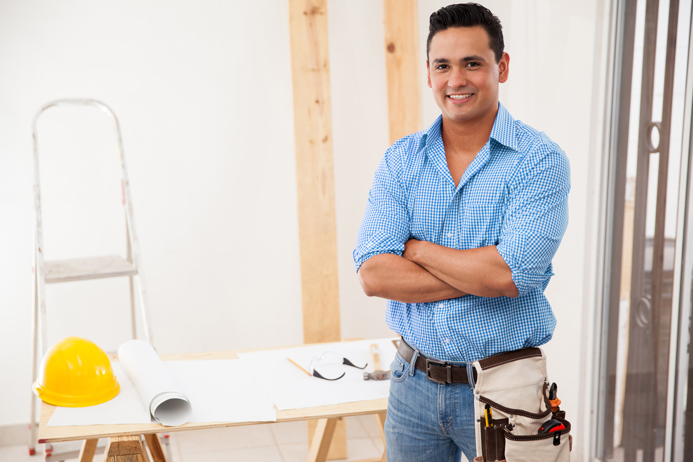 happy contractor wearing toolbelt at job site